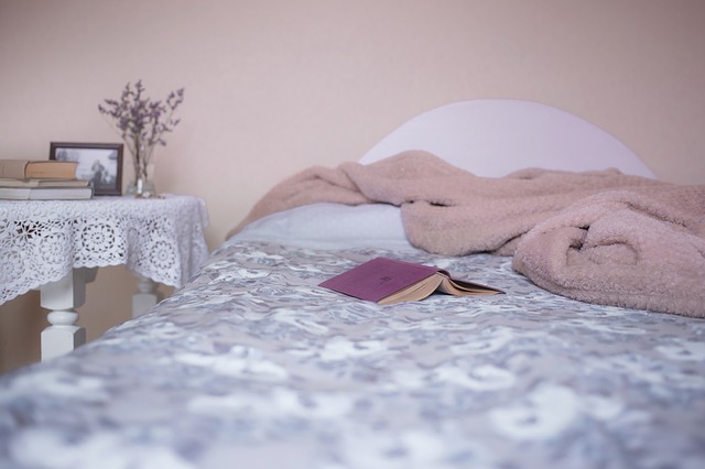 postel s růžovou dekou