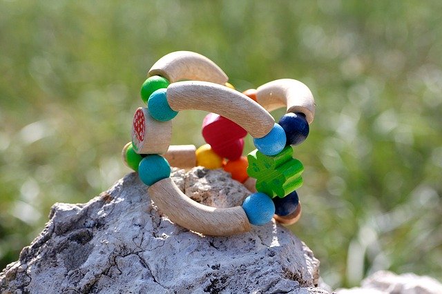 dřevěná hračka položená na kameni venku v přírodě